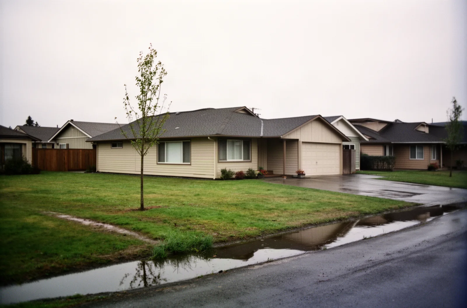 A flat-lot ranch house with a waterlogged drainage channel in Beaverton