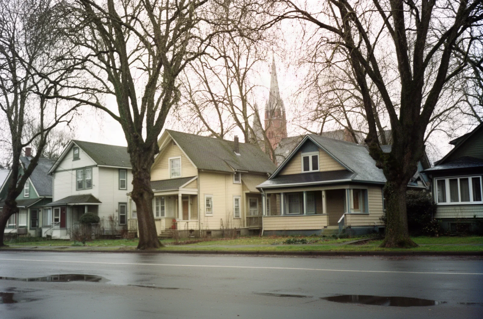 Older wood-frame houses along a wet North Portland street